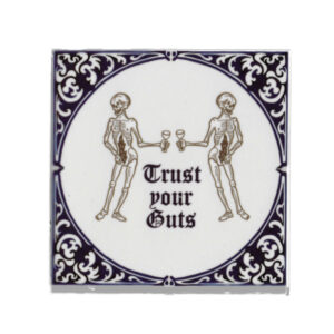 Dutch ceramic tile in delftsblauw with two gutless skeletons on it along with the text trust your guts