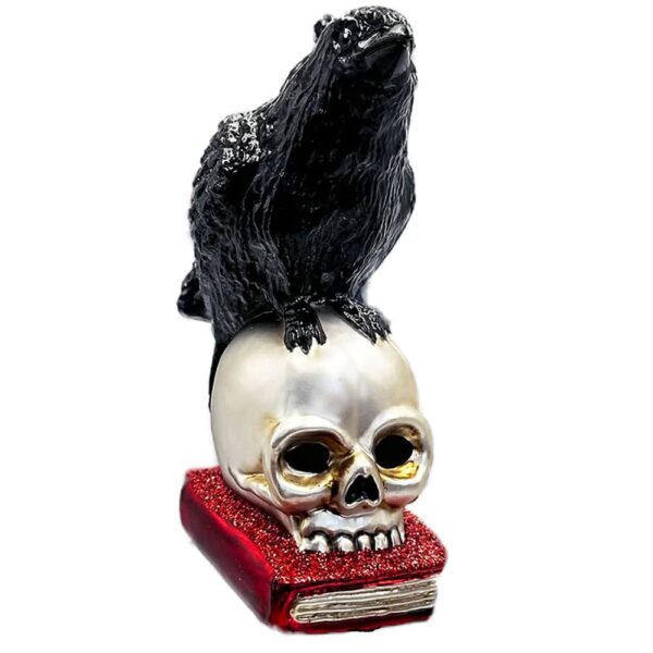 Raven on skull resting on book glass christmas ornament