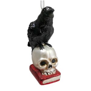 glass christmas ornament of a raven atop a skull resting on a book