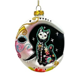 day of the dead themed glass christmas ornament of a skeleton cat sitting on the moon