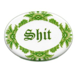 Green oval ceramic tile saying shit